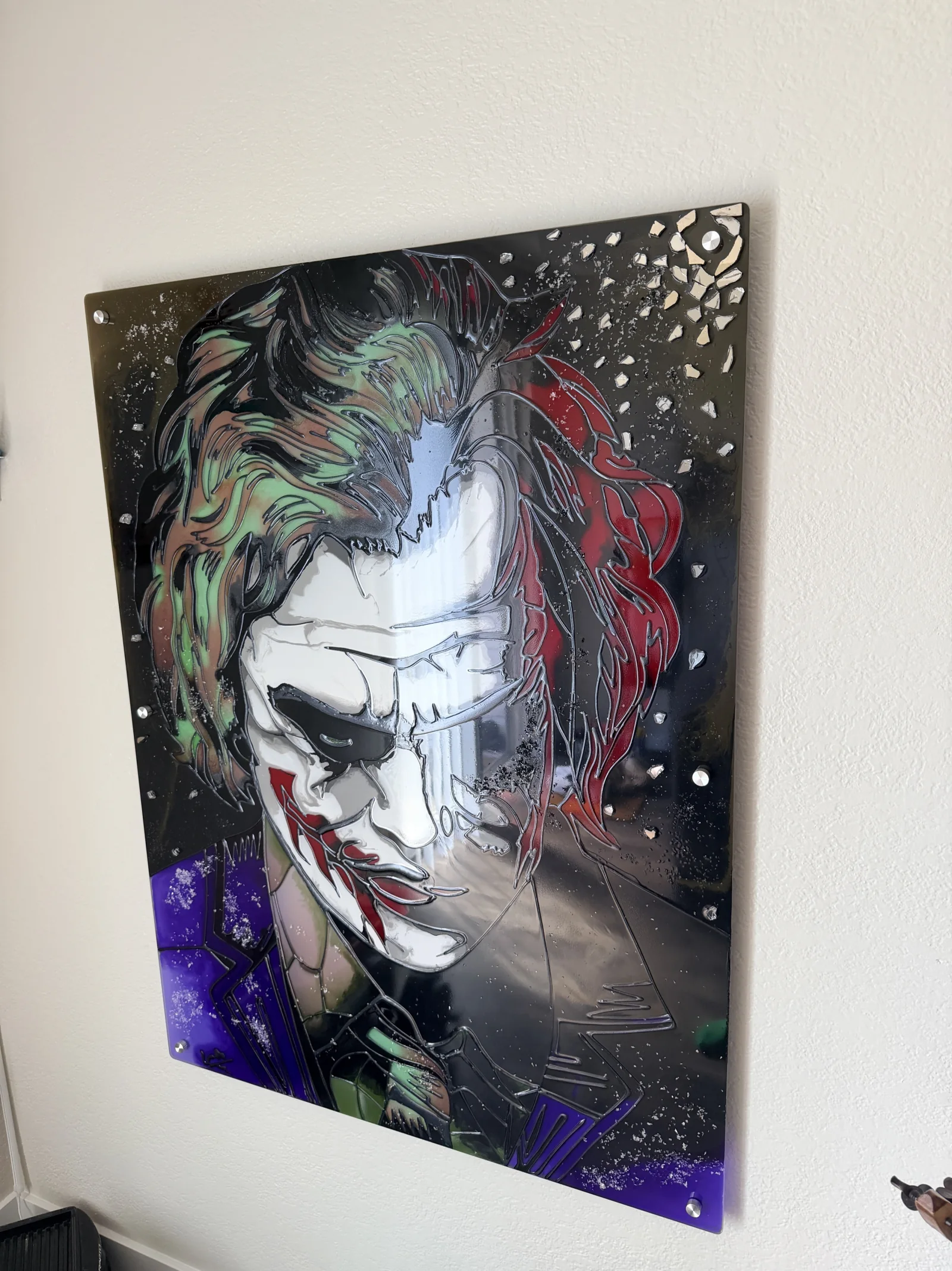 The Joker viewed from the side, where the glass reflects the room and reveals the floating standoff mount.