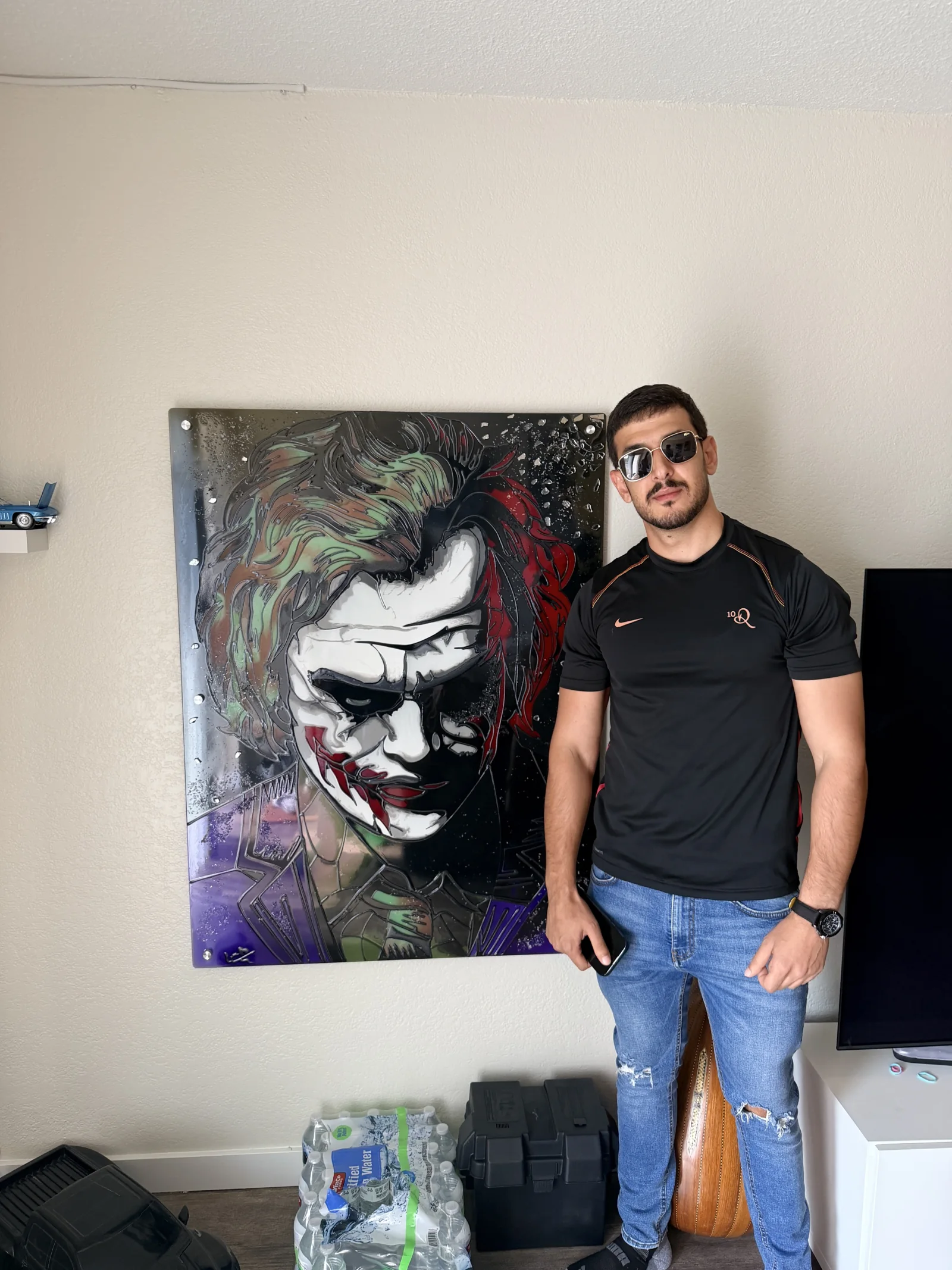 DADA standing beside The Joker, showing the scale of the mounted reverse-glass painting.